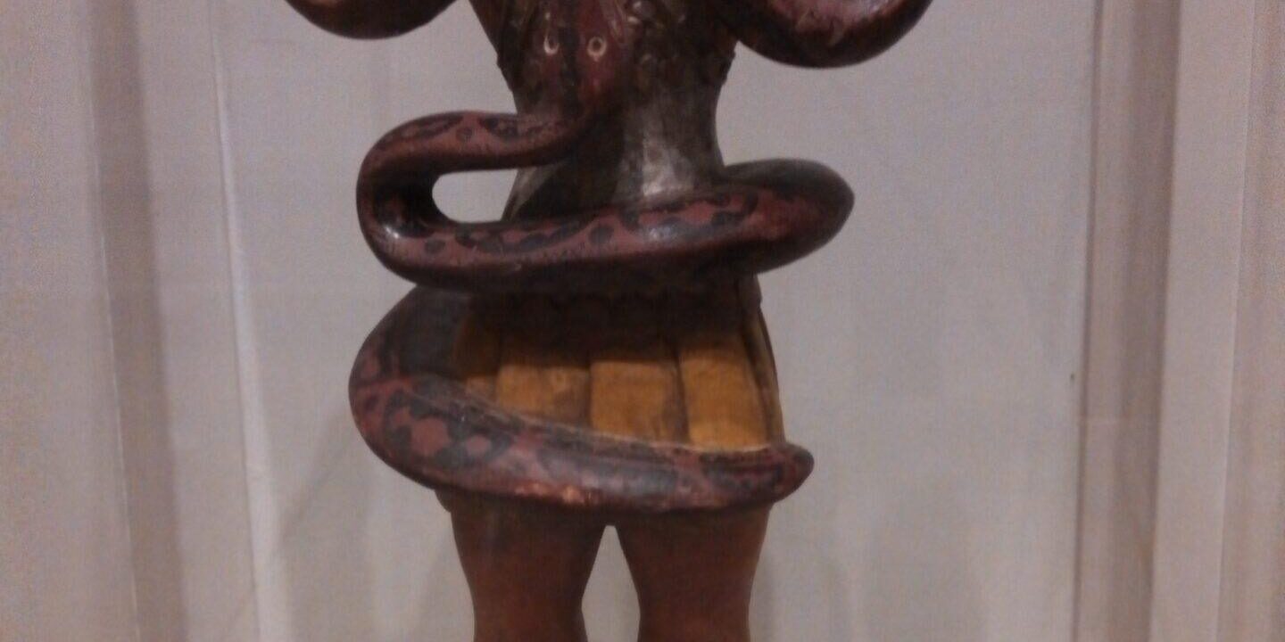 Painted wooden figurine entwined with snake Painted wooden figurine entwined with snake