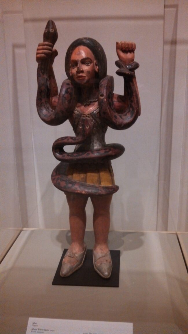 Painted wooden figurine entwined with snake
