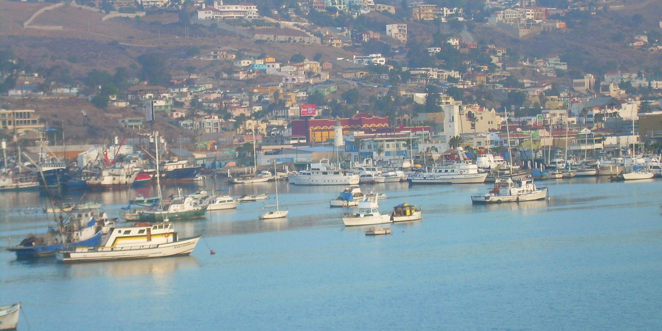 Boats moored in coastal harbor with hillside town Boats moored in coastal harbor with hillside town