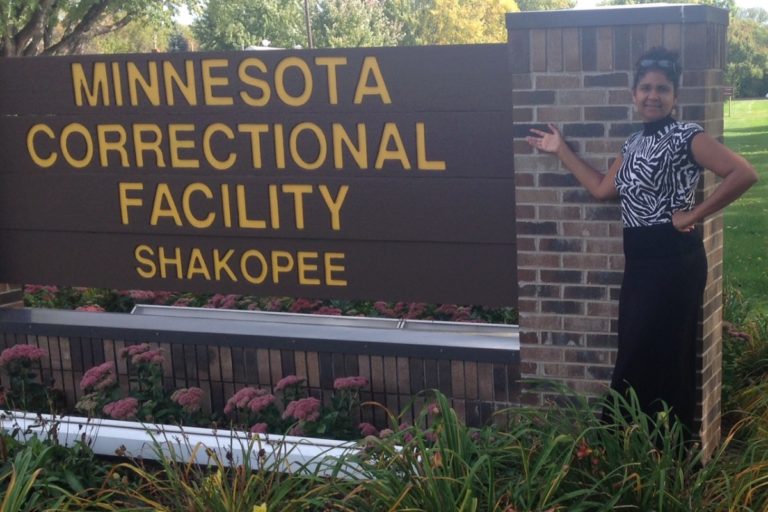 Person standing beside Minnesota Correctional Facility Shakopee sign. Person standing beside Minnesota Correctional Facility Shakopee sign.