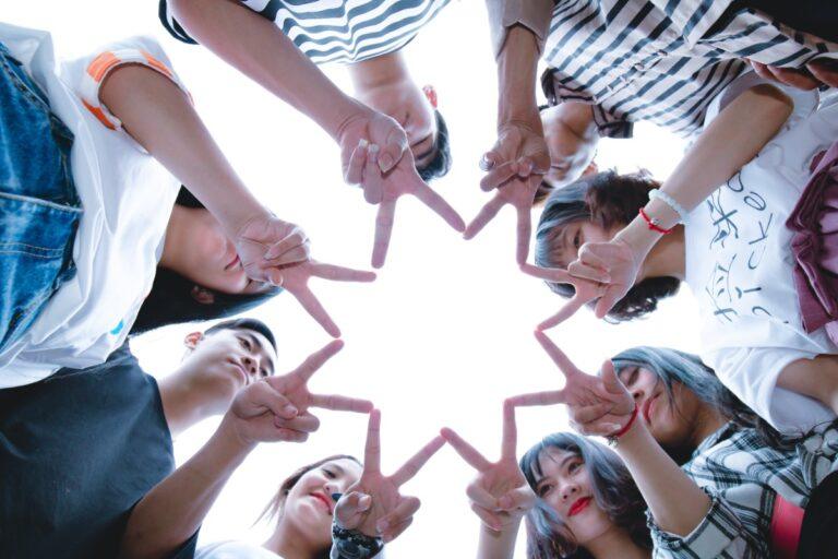 pexels-thiszun-(follow-me-on-ig-fb)-1116302 People forming a star shape with their hands while looking up.
