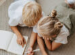 Two children reading a book together on the floor.